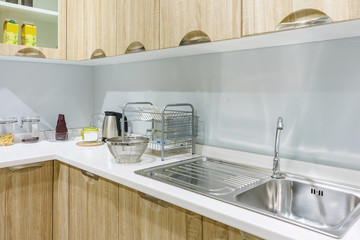 Modern, bright, clean kitchen interior with stainless steel appliances in a luxury apartment.
