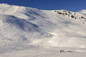 Steep gradient piste in Italian Alps against a beautiful blue sky