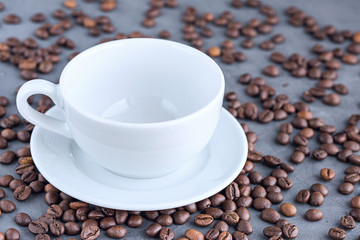 Empty coffee white cup with coffee beans close-up