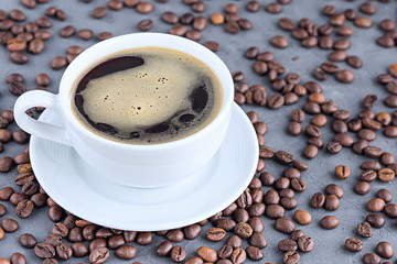 Coffee in white cup with coffee beans close-up