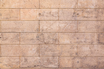 Texture of a stone porous wall, polished with a brick pattern. Background for design.