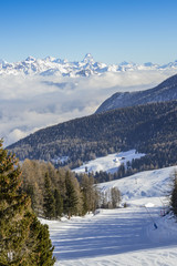 Panoramic view of wide and groomed ski piste in resort of Pila in Valle d'Aosta, Italy during winter