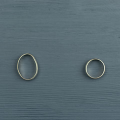 Two wedding rings. The male is flattened. The concept of severing relations, suppressing the husband's wife.