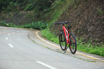 One red mountain bike on roadside of trail