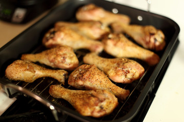 Baked chicken drumsticks cooling on top of a stove.