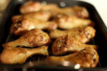 Baked chicken drumsticks cooling on top of a stove.