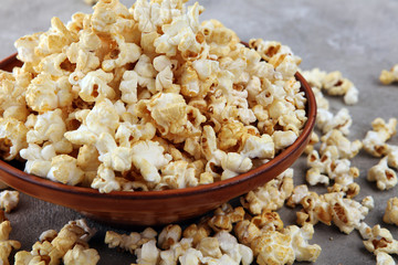 Salt popcorn or sweet popcorn on old grey background.