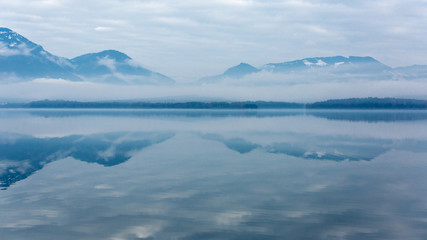 Fototapeta na wymiar Morning scene on misty mountain lake