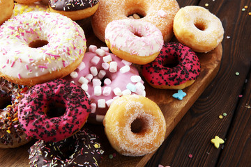 assorted donuts with chocolate frosted, pink glazed and sprinkles donuts.