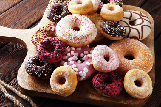 assorted donuts with chocolate frosted, pink glazed and sprinkles donuts.