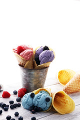 Set of ice cream scoops of different colors and flavours with blueberries, raspberries and blackberries.