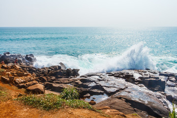 Ocean waves breaking on rocks. Beautiful oceanside. Tropical turquoise waves. Holiday and vacation concept. Exotic nature.