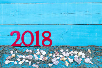Vacation sign with 2018 in bold red with seashells and netting border; travel message board with copy space