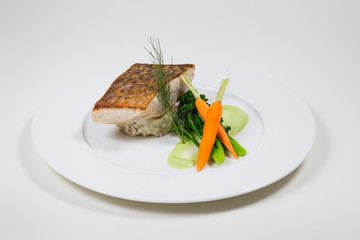Line Fish with carrots and broccoli on a white plate on a white background isolated
