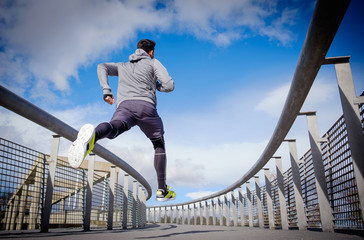 Young athlete man running in a city park