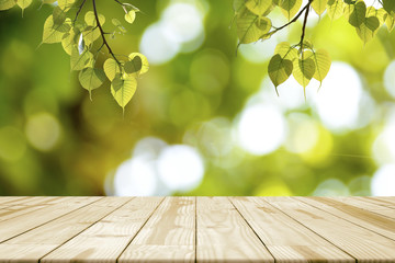 Empty wooden table and Green leaves (Bonhi) hanging for background.