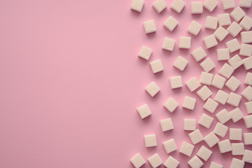 Cubes of sugar on pink background