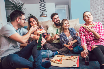 Group of young friends eating pizza.Home party.Fast food concept.