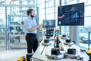 Engineer testing a robotic production simulator in robotics research facility