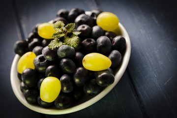 Blueberries and grapes on white bowl