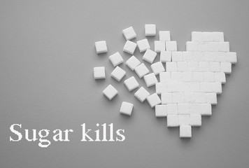 Broken heart made of sugar cubes. Rupture of relations. Sugar kills. Gray background. Empty space for copying text.