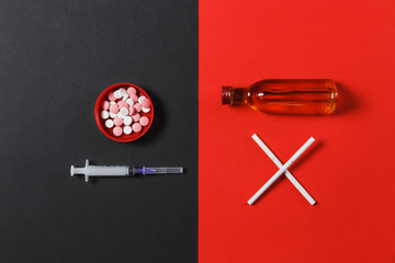 Medication round tablets pills, empty syringe needle, bottle with alcohol cognac, whiskey, two crossed cigarettes on black red background. Choice healthy lifestyle. Copy space for advertising.