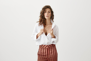 Studio shot of attractive sexy european female with curly hair looking sensual and hot while...
