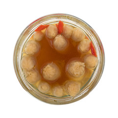Top view of marinated white asparagus with seasonings in an opened jar isolated on a white background.