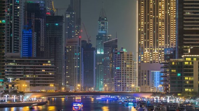 Evening Dubai marina city centre with floating vessels day to night timelapse