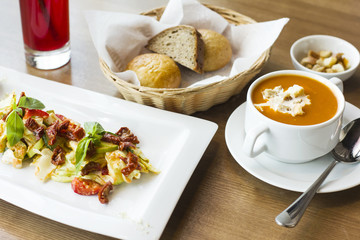 Lunch on the table: tomato puree soup, salad of fresh vegetables and sun-dried tomatoes and bread