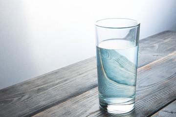 glass of crystal-clear water on a wooden background