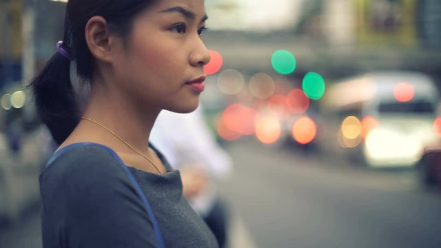 Portrait of young Asian Woman waiting at bus stop toned video with selective focus 4k UHD (3840x2160)
