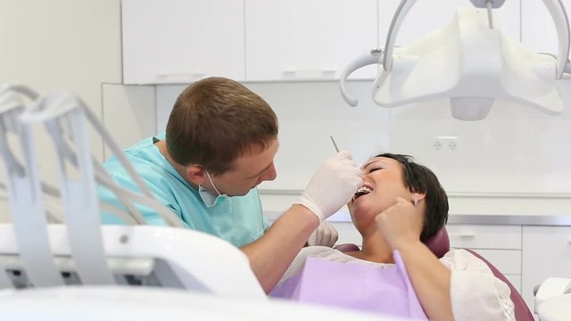 adult dentist with smiling patient woman sitting in medical Center