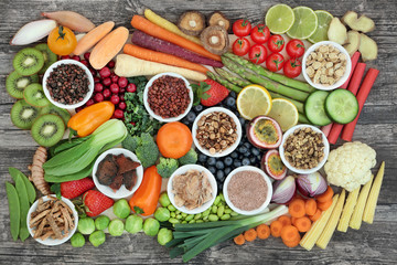 Healthy super food sampler with fresh vegetables, fruit and herbal medicine, in porcelain dishes...