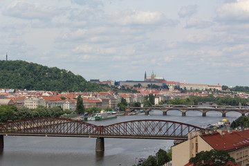Fototapeta premium Bridges over Vltava river, Prague, Czech Republic. St. Vitus Cathedral םn the horizon, cloudy sky above.