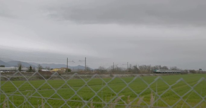 Passaggio treno passeggeri vicino a un prato