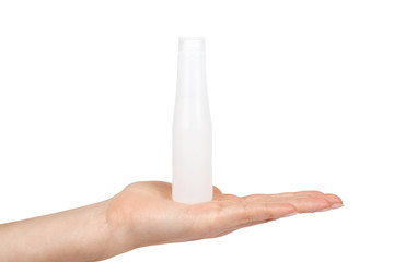 Transparent travel bottle, hotel bathroom shampoo in hand. Isolated on white background