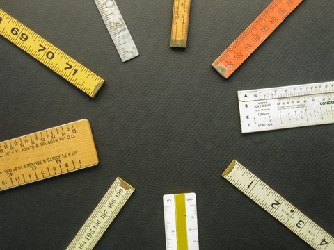 An arrangement of rulers, scales and measuring tools suggests concepts of measurement, metrics, precision, accuracy and results.