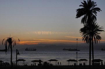 sunset on a beach / Sunset on a beach in Aqaba bay with big vessels in the background, Aqaba, Jordan
