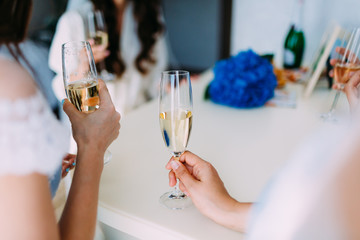 Bridesmaids celebrate and drink champagne from wineglasses