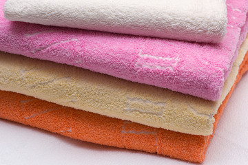 Colorful folded towels stack closeup picture.