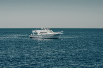 Plakat white boat, yacht in the calm sea, against the background of the horizon and sky without clouds, toning