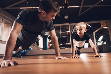Fototapeta na wymiar Father and son in the gym. Father and son spend time together and lead a healthy lifestyle.