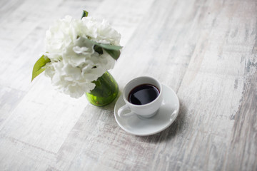 Female hands holding cups of coffee on rustic wooden background
