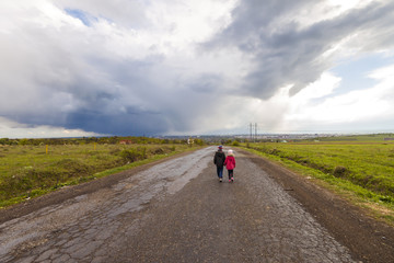 Fototapeta na wymiar Two little children boy and girl walking on a road