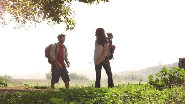 Young lovely couple backpackers tourists reading map pointing directions roman aqueduct arches in parco degli acquedotti park ruins in rome on romantic misty sunrise with guitar and sleeping bag slow