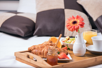 Tray with breakfast food on the bed inside a bedroom