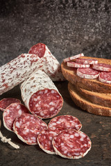 Salami slices on the wooden table. Spicy and tasty.