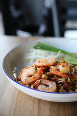 Pad thai with shrimp . Thai food on wood background