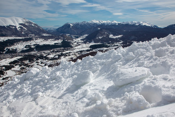 Fototapeta na wymiar Manto di neve in primo piano e montagne sullo sfondo
